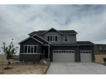 Two-story home with gray siding, a two-car garage, and a well-manicured lawn on a cloudy day at 13960 Hanging Lake St, Parker, CO 80138