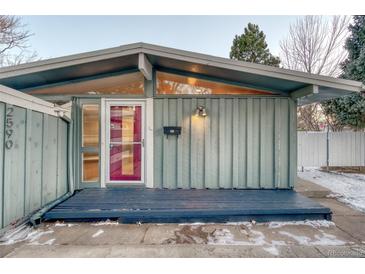 Mid-century modern home with a gray exterior, red door, and dark deck at 2590 S Meade St, Denver, CO 80219