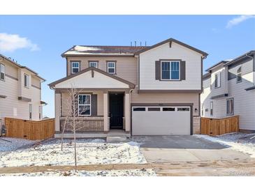 Charming two-story home featuring a covered porch and an attached two-car garage at 9165 Truckee Ct, Commerce City, CO 80022