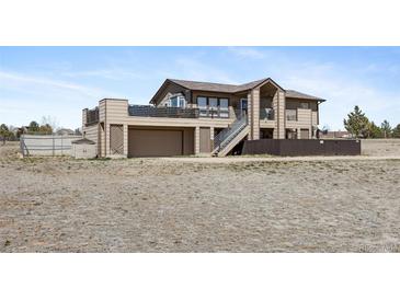 Two-story home with a deck, stairs, and attached garage for convenient parking and outdoor enjoyment at 59 S De Gaulle St, Aurora, CO 80018