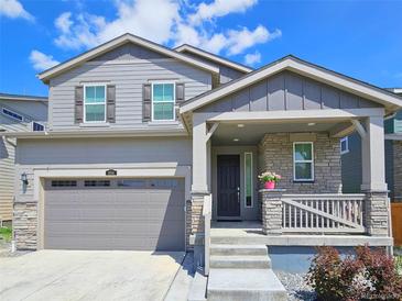 Charming two-story home with gray siding, stone accents, and a covered front porch at 656 N Bersshine St, Watkins, CO 80137