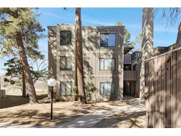 Multi-level condo complex with neutral-colored siding and mature trees surrounding the building at 2525 S Dayton Way # 1514, Denver, CO 80231