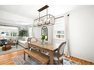 Bright dining room features hardwood floors, modern lighting, and a rustic wood table and bench seating at 1757 S Elm St, Denver, CO 80222