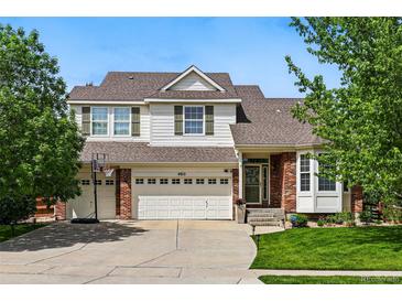 Charming two-story home with a well-manicured lawn, three-car garage, and brick and siding facade at 4915 Sage Brush Dr, Broomfield, CO 80023