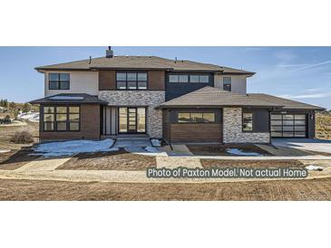 Beautiful two story home featuring a stone, wood, and stucco exterior with a three car garage at 9752 Canyon Wind Pt, Parker, CO 80138