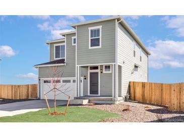 Inviting two-story home featuring a gray exterior, well-kept lawn, and attached two-car garage at 17850 E 94Th Ave, Commerce City, CO 80022