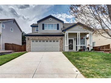 Charming two-story home featuring a brick garage and a welcoming front porch with stylish columns at 10554 Tracewood Cir, Highlands Ranch, CO 80130