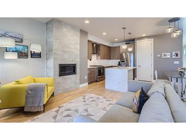 Open-concept living room featuring a fireplace, modern kitchen, and stylish furnishings at 1439 Garfield St, Denver, CO 80206
