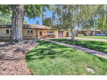 Charming ranch-style home with a well-manicured lawn and mature trees providing shade at 4960 S Fox St, Englewood, CO 80110