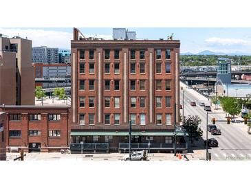 Brick apartment building with street view and mountain backdrop showcasing city living at 2261 Blake St # 2G, Denver, CO 80205