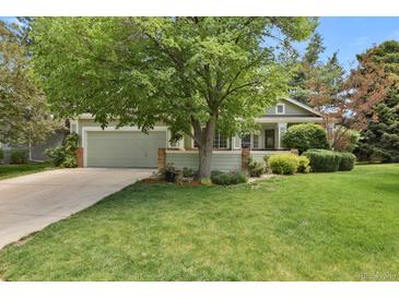 Charming home featuring a lush green lawn and mature shade tree in a desirable neighborhood at 1894 S Marshall Cir, Lakewood, CO 80232