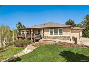 Charming ranch home with a stone facade, landscaped yard, and inviting deck, perfect for outdoor entertaining at 20413 Bald Mountain Ct, Monument, CO 80132