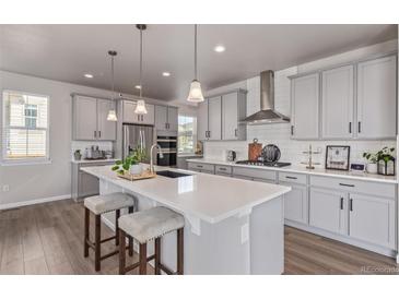 Modern kitchen features stainless steel appliances, a center island with seating, and stylish pendant lighting at 434 W 128Th Dr, Westminster, CO 80234