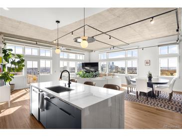 Bright, open living space with modern kitchen, stainless steel appliances, and city views at 1925 W 32Nd Ave # 502, Denver, CO 80211