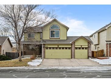 Two-story house with a green facade, two-car garage, and well-maintained lawn at 10463 Adams St, Northglenn, CO 80233