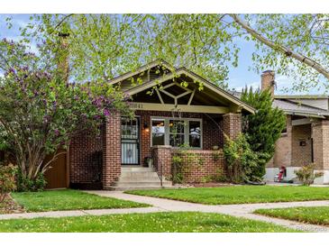 Charming brick bungalow featuring well-maintained lawn and beautiful landscaping at 2641 N Clayton St, Denver, CO 80205