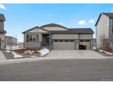 Charming single-Gathering home with a three-car garage, stone accents, and a well-maintained lawn on a sunny day at 1947 S Coolidge Way, Aurora, CO 80018