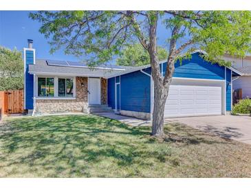 Charming blue home with stone accents, solar panels, well-kept lawn, and attached two-car garage at 3854 S Olathe Cir, Aurora, CO 80013