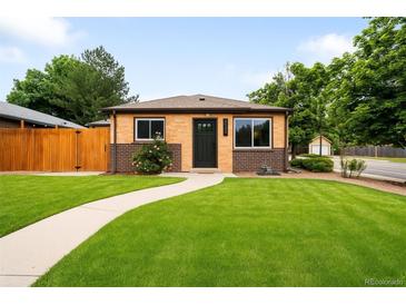Charming brick home featuring a well-manicured lawn and inviting walkway leading to a dark front door at 2255 Perry St, Denver, CO 80212