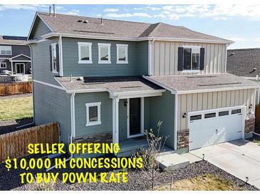 Charming two-story home with a two car garage, inviting front porch and stone accents under a blue sky at 17947 E 95Th Ave, Commerce City, CO 80022