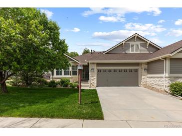 Charming home with a well-manicured front lawn, mature tree, and a two-car garage at 8216 S Tempe Ct, Aurora, CO 80016
