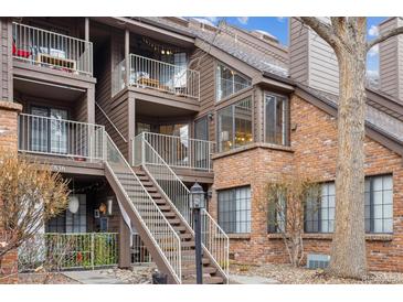 Multi-level condo building with brick and siding exterior, featuring balconies and well-maintained landscaping at 836 S Vance St # E, Lakewood, CO 80226