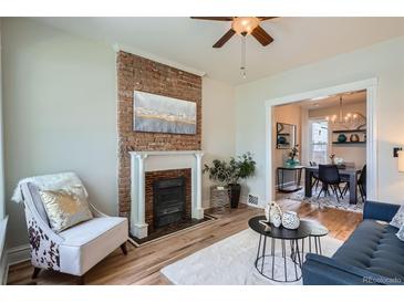 Inviting living room with exposed brick fireplace, modern decor and natural light, creating a cozy and stylish atmosphere at 2564 N Emerson St, Denver, CO 80205