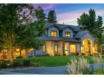 Charming two-story home with a well-manicured lawn and mature trees, creating a picturesque setting at 4181 S Ivy Ln, Cherry Hills Village, CO 80111