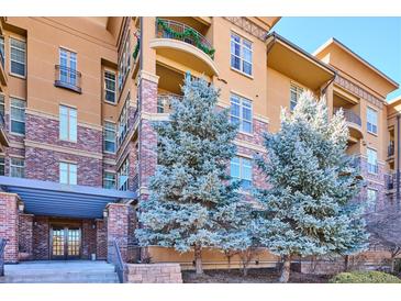 Attractive condo building with brick and stucco exterior and nicely landscaped entrance at 7865 Vallagio Ln # 207, Englewood, CO 80112