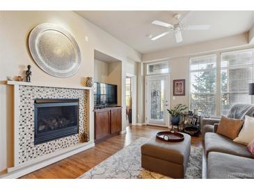 Inviting living room featuring a tiled fireplace, ceiling fan, and neutral tones at 7865 Vallagio Ln # 207, Englewood, CO 80112