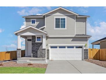 Charming two-story home with gray siding, stone accents, and a two-car garage in a Gathering-friendly neighborhood at 9454 Yampa St, Commerce City, CO 80022
