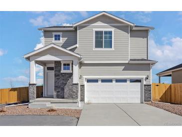 Charming two-story home featuring a two-car garage and stone accents at 9454 Yampa St, Commerce City, CO 80022