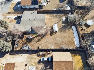 An aerial view of a property with a large yard and neighboring houses at 8280 E 104Th Way, Henderson, CO 80640
