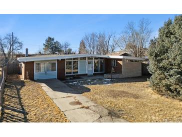 Charming single-story home with a brick facade and large windows showcasing a mid-century modern design at 8280 E 104Th Way, Henderson, CO 80640