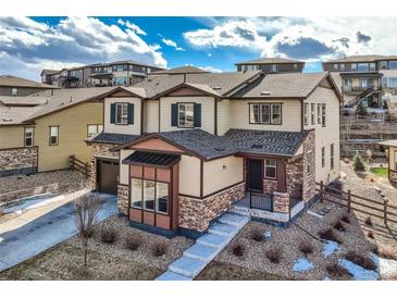 Beautiful two-story home with stone accents, a covered front porch, and well-maintained landscaping at 7897 S Jamestown Ct, Aurora, CO 80016