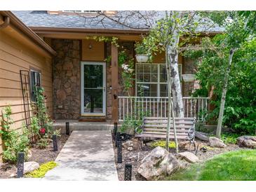 Charming stone-accented home entrance with landscaped walkway and cozy porch seating at 424 Arbor Dr, Lafayette, CO 80026