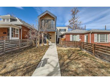 Modern two-story home with sleek design, balcony, and well-maintained walkway leading to the front entrance at 3439 N High St, Denver, CO 80205