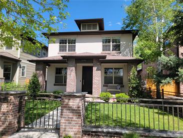 Charming two-story home featuring brick accents, a well-manicured lawn, and inviting curb appeal at 1152 S Ogden St, Denver, CO 80210