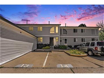 Two story home showcasing beautiful landscaping and a shared parking area at dusk at 5145 W 61St Dr # 14, Arvada, CO 80003