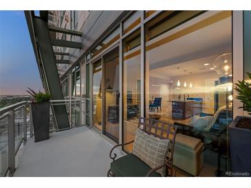 Relax on this unit's balcony with chair and enjoy city views through large sliding glass doors at 2001 Lincoln St # 2412, Denver, CO 80202
