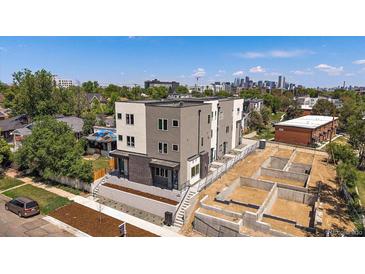 Aerial view of modern home with landscaping and city skyline in the background at 1372 Lowell Blvd # 1, Denver, CO 80204