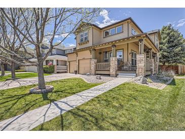 Charming two-story home featuring a welcoming porch with stone accents and a well-manicured front yard at 16376 Flintlock Ct, Parker, CO 80134