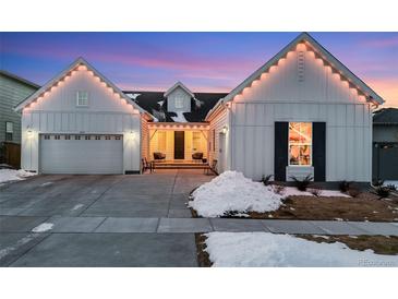 Stunning farmhouse exterior with charming string lights and landscaping at 14319 Hop Clover St, Parker, CO 80134