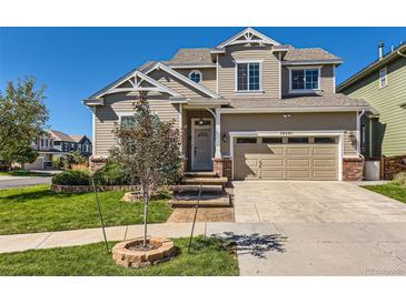 Two-story home with a beige exterior, well-kept lawn, and mature landscaping, creating a welcoming curb appeal at 10201 Rifle St, Commerce City, CO 80022