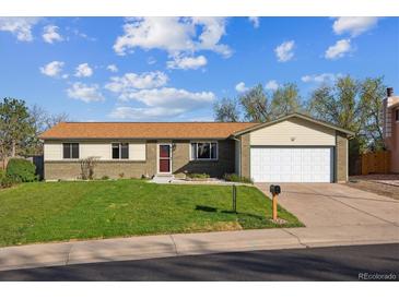 Charming single-story home with a well-maintained lawn, brick facade, attached garage and inviting curb appeal at 16246 E Hamilton Pl, Aurora, CO 80013
