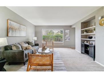 Cozy living room with large windows and built-in shelving offers comfortable and stylish seating at 9283 E Arbor Cir # C, Englewood, CO 80111