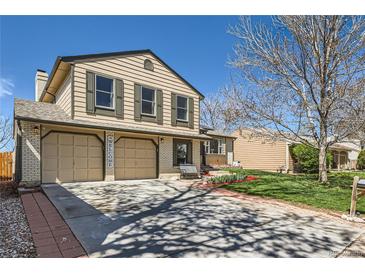 Charming two-story home with a two-car garage and manicured front lawn on a sunny day at 2023 S Rifle St, Aurora, CO 80013