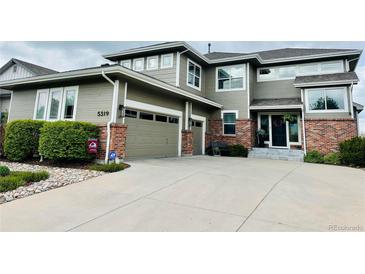 Charming two-story home featuring a two-car garage, brick accents, and landscaped front yard in a well-maintained neighborhood at 5319 W Hoover Dr, Littleton, CO 80123