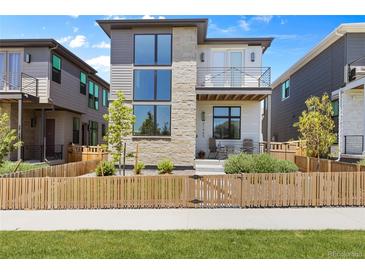 Charming two-story home with a mix of stone and siding and a cozy front porch and gated front yard at 21405 E 59Th Dr, Aurora, CO 80019