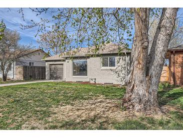 Charming single-story home with a gray brick exterior, well-manicured lawn, and attached garage at 3075 Fairfax St, Denver, CO 80207